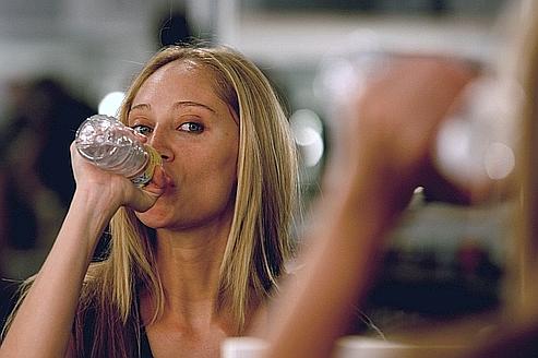 A model drinks water as she is reflected in a mirror during a break at the Pasarela Cibeles Autumn/Winter 07-08 fashion week in Madrid February 13, 2007. REUTERS/Sergio Perez (SPAIN)