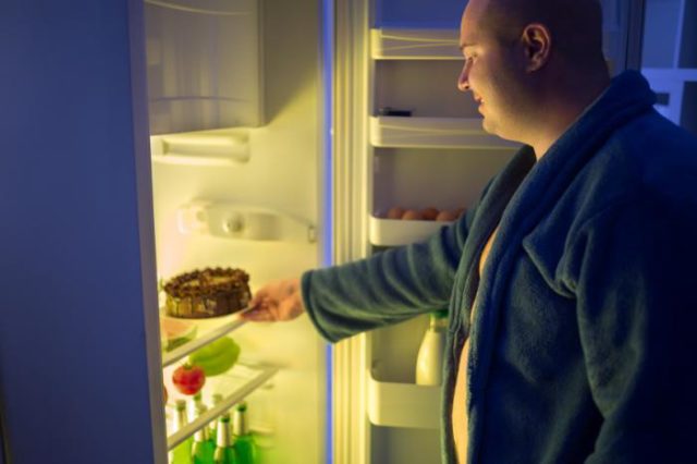 man-getting-cake-from-fridge-at-night