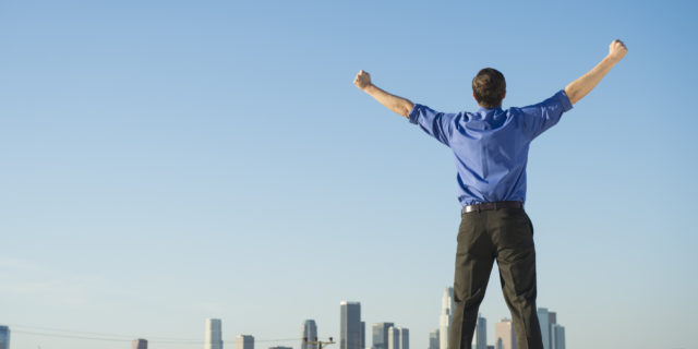 Caucasian businessman standing on urban rooftop