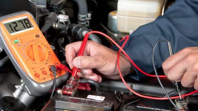 Auto-mechanic-checking-car-battery-voltage-869